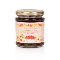 A glass jar of strawberry and champagne jam. On the wrapper, is a garland of strawberries and gold leaves. At the centre are the words 'Buckingham Palace' in gold and 'Strawberry and Marc De Champagne Preserve' in pink. Underneath the writing is a white b