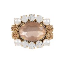 Pink oval crystal surrounded by orange and clear crystals and four costume pearls. 