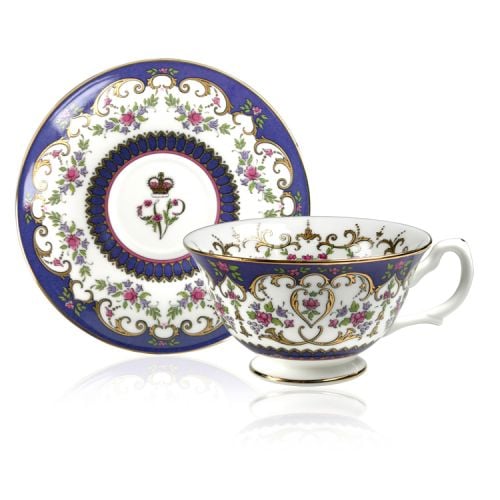 Queen Victoria teacup and saucer with design featuring Queen Victoria's name cipher surrounded by floral patterns and gold plated rim.