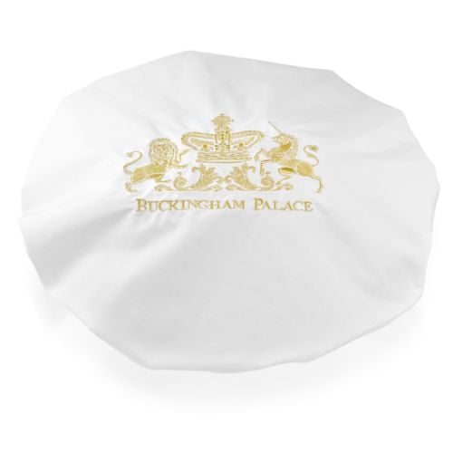 Buckingham Palace logo white shower cap featuring the gold embroidered words Buckingham Palace under a lion and unicorn royal crest.