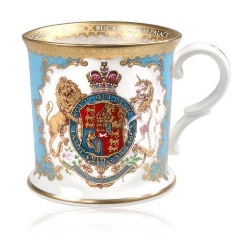 Royal coat of arms fine bone china tankard featuring a lion and unicorn royal crest surrounded by ornated gold patterns and flower patterns on a light blue coloured background. Gold plated with the words Buckingham Palace, Windsor Castle and Palace of Hol