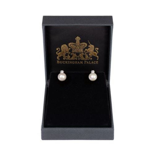 A pair of pearl stud earrings with a diamante attached to the top of the pearl