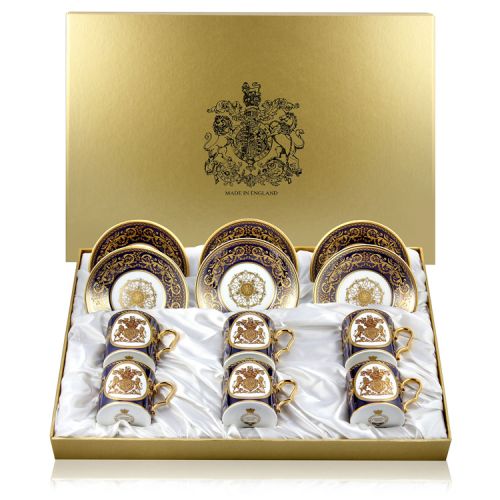 The full set of 6 English Fine Bone China lustre coffee cups and saucers featuring a gold hanoverian coat of arms surrounded by ornated patterns on a cobalt blue background and displayed in a giftbox. 