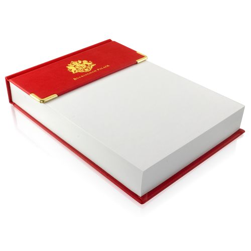 Red leather desk pad, with sheets of white note paper. With gold crest and the words 'Buckingham Palace' on the red leather
