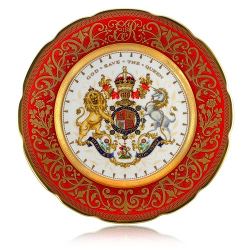 The official commemorative Coronation English fine bone china plate with a design featuring a royal coat of arms cicled by gold ornamental features on a red background border. 
