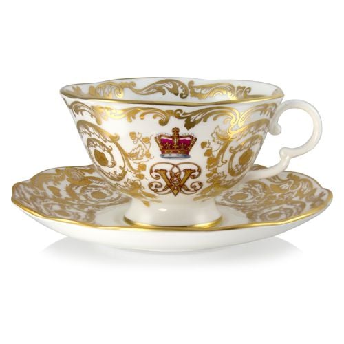 Victoria and Albert teacup and saucer featuring the ciphers of Queen Victoria and Prince Albert surmounted by a royal crown and surrounded by intricately ornated gold patterns and gilded rims.