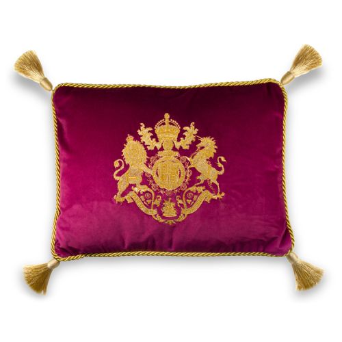 Buckingham Palace pink velvet cushion featuring an embroidered royal coat of arms with golden rope borders and tassels in each corner. 
