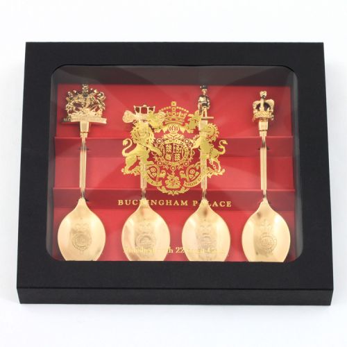 Red and black box of four golden spoons topped with different royal symbols including a crest, crown, guardsman and carriage.