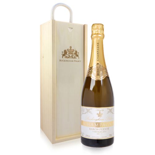 bottle of champagne with gold foil and white and gold  'Buckingham Palace' label next to a wooden bottle box etched with the crest and 'Buckingham Palace'