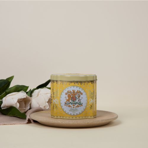 Tin tea caddy is yellow and decorated with the Royal Coat of Arms, leaves tied with bows and acorns.  