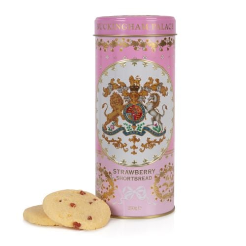 pink biscuit tin with the crest at the centre of the tin. Stood next to a tower of strawberry biscuits