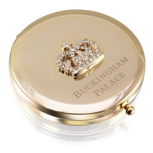 Gold circular compact mirror. With a crystal crown on top and the words 'Buckingham Palace' etched on the lid