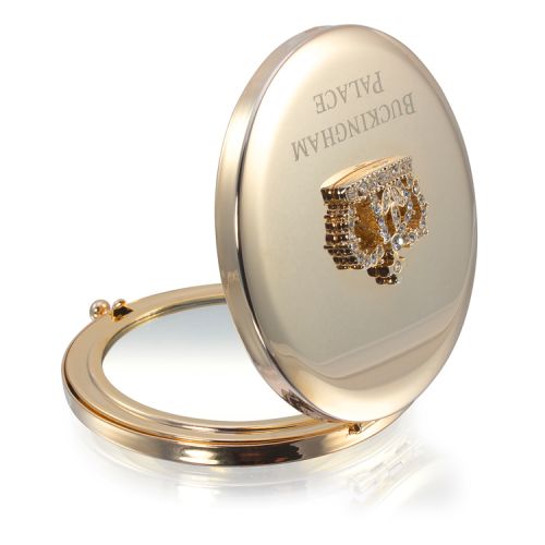 Gold circular compact mirror. With a crystal crown on top and the words 'Buckingham Palace' etched on the lid