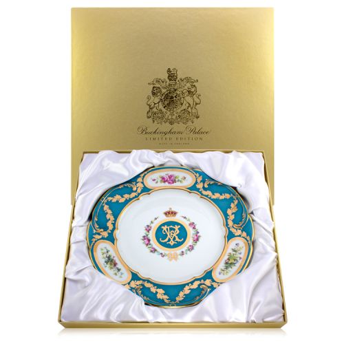 Blue and white china plate. At the centre is Queen Victoria's cypher - an entwined V & R in a blue circle with gold edge. Topped with a crown and surrounded by flowers and a bow. The edge of the plate is blue and finished with gold leaves, hand-painted fl