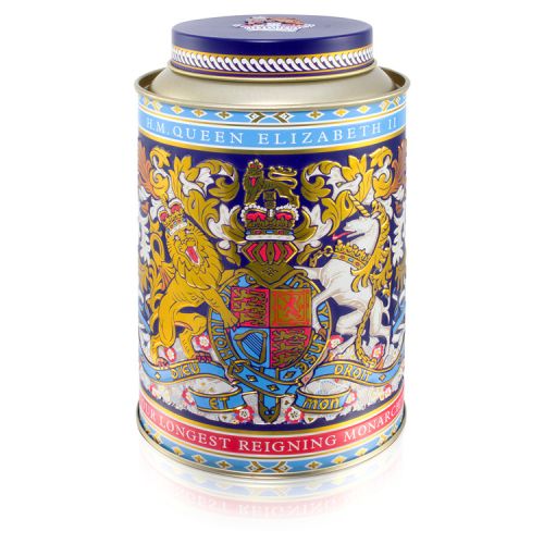 Round tin with the lion and unicorn design at the centre. The lid and edges of the tea caddy are in a gold, purple and light blue design. 