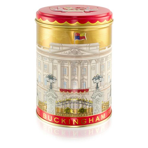 Gold tea caddy with lid off. Round teabags inside. Red lid with lion on a crown and flags surrounding. The main body of the tea caddy has the Buckingham Palace facade wrapped around. 