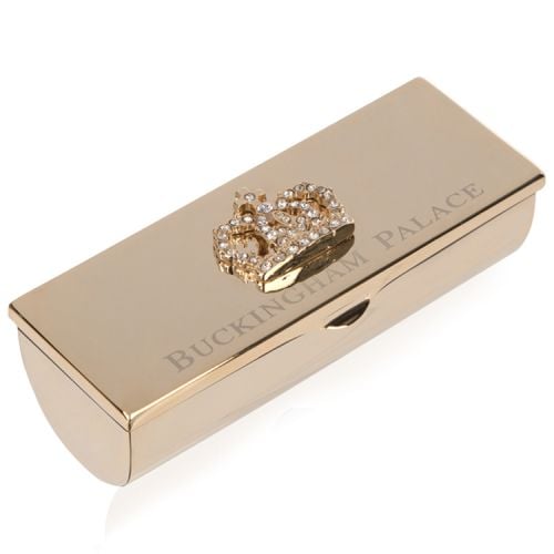 gold lipstick holder with a crown on top and the words 'Buckingham Palace' etched onto the lid