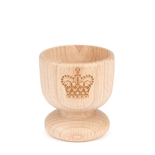 Wooden egg cup with crown motif cut into the front. 