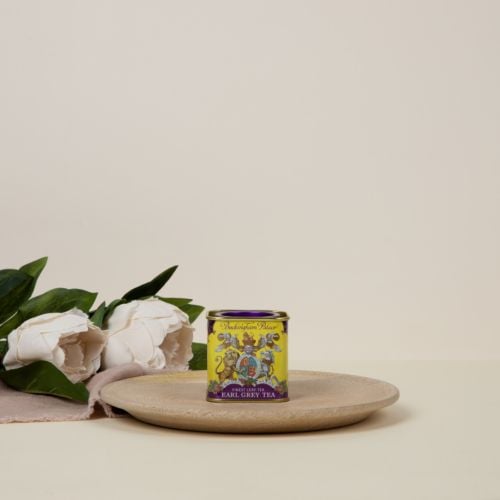 Small tin Earl Grey Tea tea caddy with a purple and yellow design and a lion and unicorn crest at the centre of the design