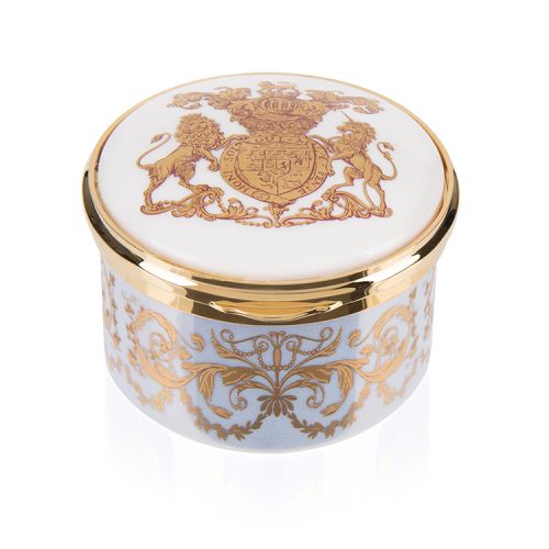 Blue,  white and gold pillbox. The edge of the pillbox is blue with swirly gold design. The lid is white with the gold lion and unicorn crest