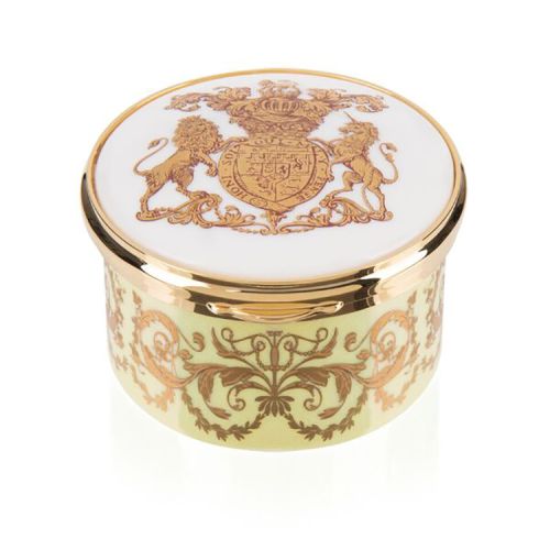 Yellow, white and gold pillbox. The edge of the pillbox is yellow with swirly gold design. The lid is white with the gold lion and unicorn crest