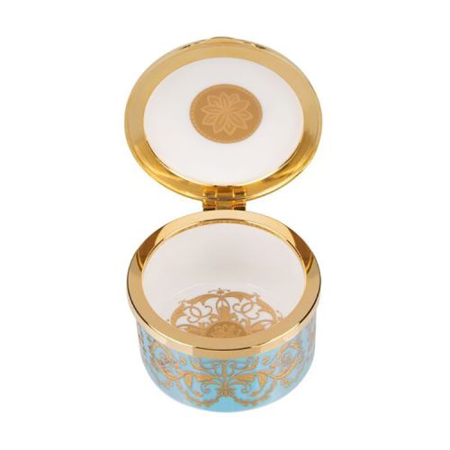 Turquoise, white and gold pillbox. The edge of the pillbox is turquoise with swirly gold design. The lid is white with the gold lion and unicorn crest