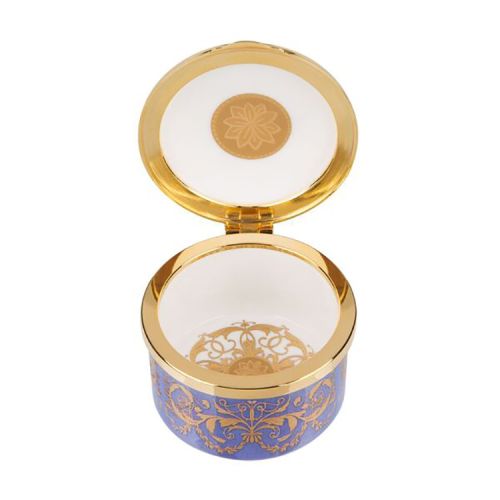 Purple, white and gold pillbox. The edge of the pillbox is purple with swirly gold design. The lid is white with the gold lion and unicorn crest