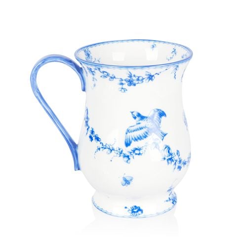 A white coffee mug with blue floral garland and bird design.