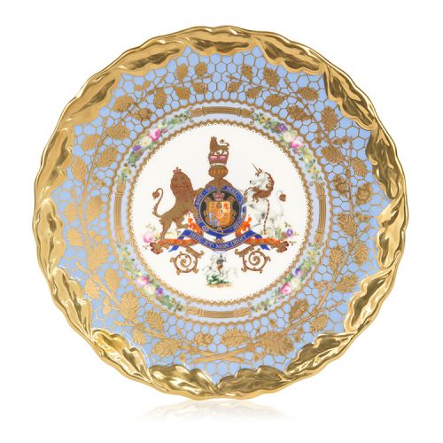 Face of the cake stand plate. A lion and unicorn coat of arms at the centre. Surrounded by light blue and gold leaf with a gold rim