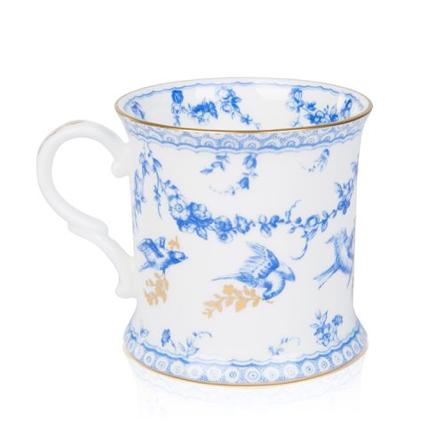 White tankard with a blue floral garland and bird design and finished with gold detail and gold edge of the tankard. At the centre of the tankard are the words 'Buckingham Palace' in blue