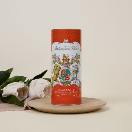 Orange cardboard tube of Hazelnut and dark chocolate biscuits. The lion and unicorn crest is at the centre of the design underneath the words 'Buckingham Palace'