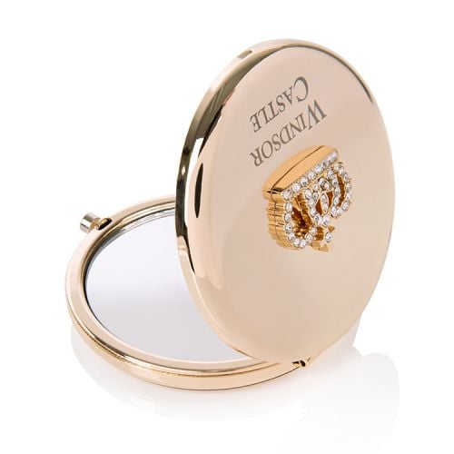 Round, gold compact mirror with Windsor Castle engraved on the top and a crown encrusted with clear crystals. 