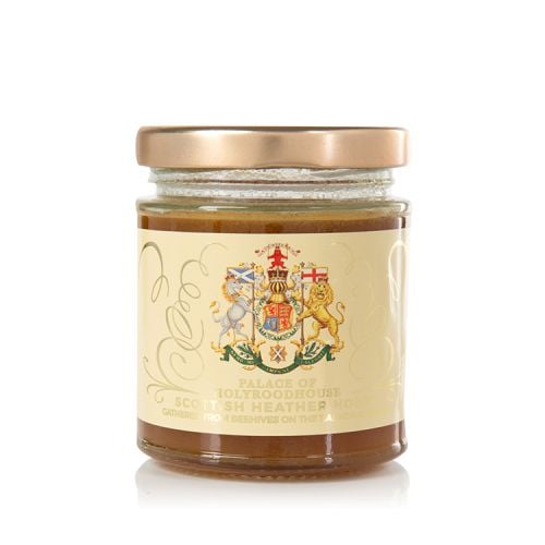 Glass jar of honey with gold lid. The jar is wrapped with a label displaying the Scottish Coat of Arms.