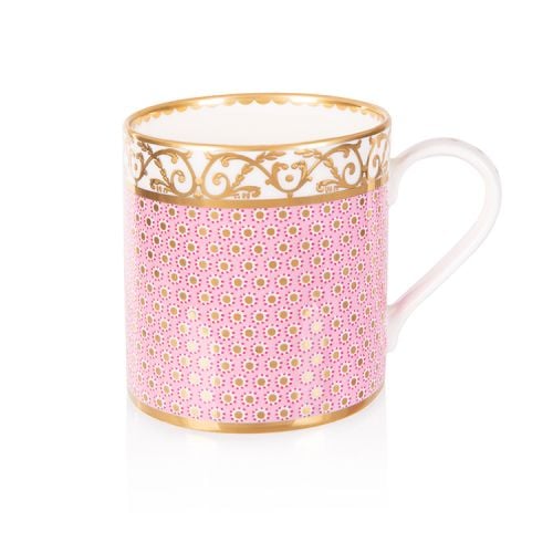 pink patterned coffee mug with a gold design and white handle