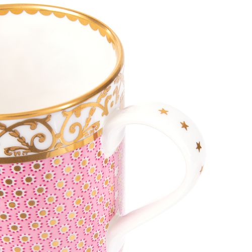 pink patterned coffee mug with a gold design and white handle