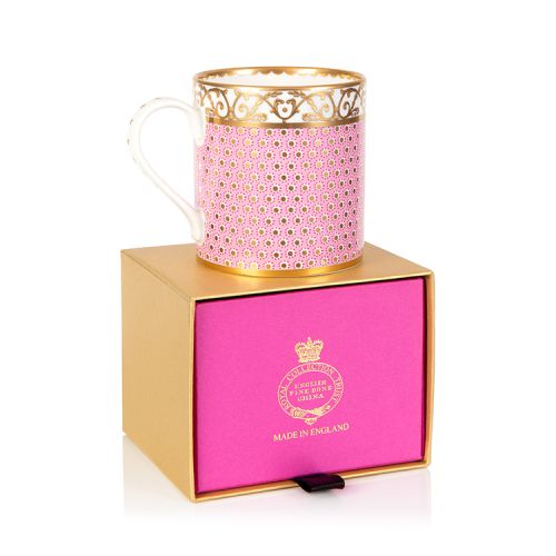 pink patterned coffee mug with a gold design and white handle