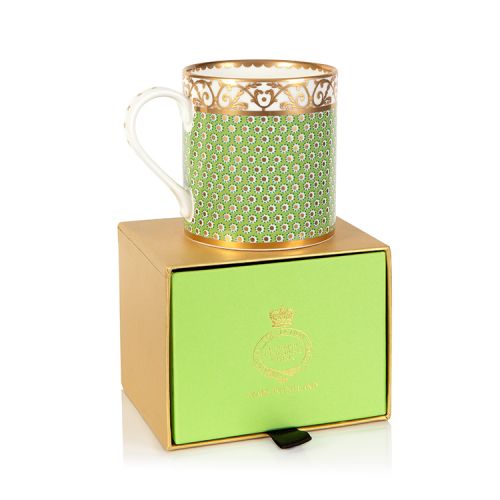 green patterned coffee mug with a gold design and white handle