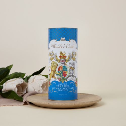 blue cardboard tube of salted caramel and milk chocolate biscuits with crest at the centre. There are two biscuits next to the tube