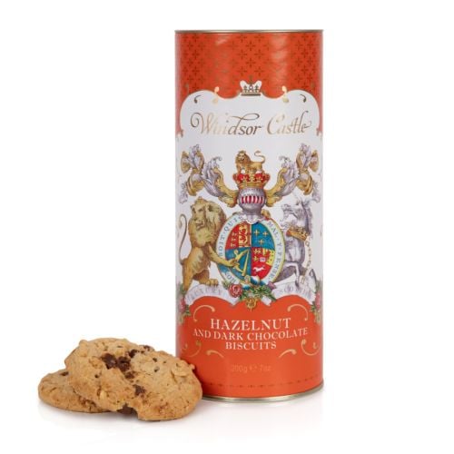 Orange cardboard tube of Hazelnut and dark chocolate biscuits. The lion and unicorn crest is at the centre of the design underneath the words 'Windsor Castle.' Next to the tube are two biscuits.