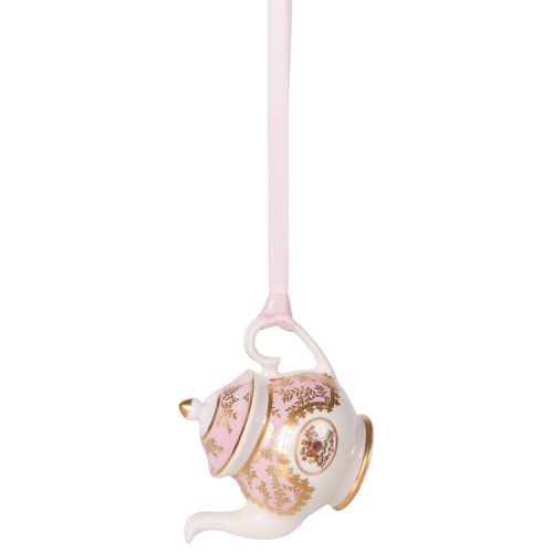 Miniature pink teapot with gold crown detail. It is  hanging from a pink ribbon