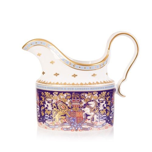 Longest reigning monarch milk jug. Oval shaped purple milk jug with an ornate crest and a white and gold spout and handle