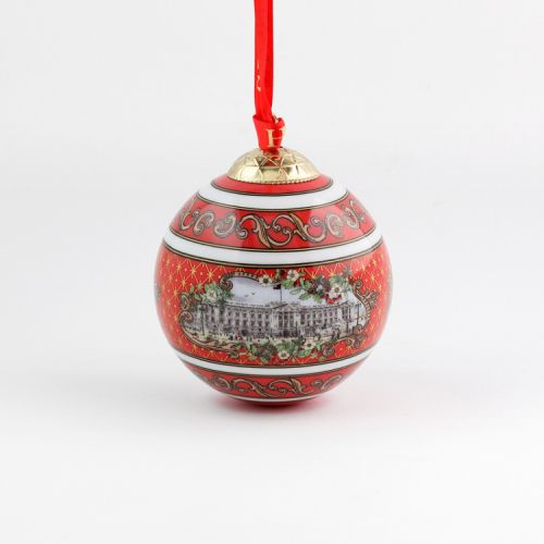 Christmas bauble with red and gold pattern surrounding an illustration of Buckingham Palace