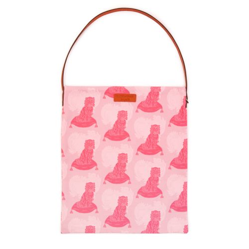 A light pink tote bag with a print of a pink dog with brown leather handle