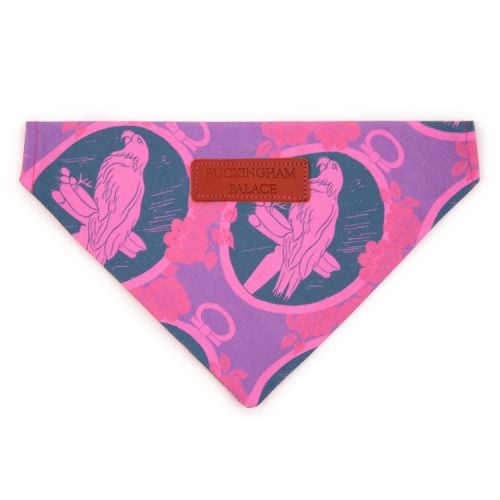 Pet bandana printed with a purple and blue parrot material. Finished with a leather tag saying 'Buckingham Palace'