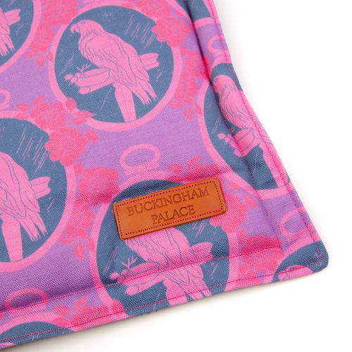 Square pet cushion printed with purple parrot printed material with a leather tag saying Buckingham Palace