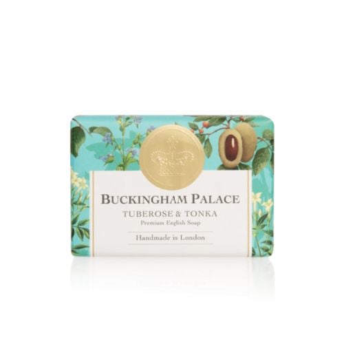 bar of soap wrapped in blue paper printed with tuberose and tonka beans. There is also a gold seal with a crown and a white box saying 'Buckingham Palace Tuberose and Tonka Premium English Soap Handmade in London'