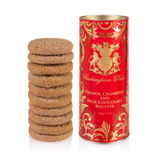 red tube of biscuits with gold swirl and crest with the words 'Buckingham Palace Orange, Cranberry and Milk Chocolate Biscuits' next to a pile of biscuits