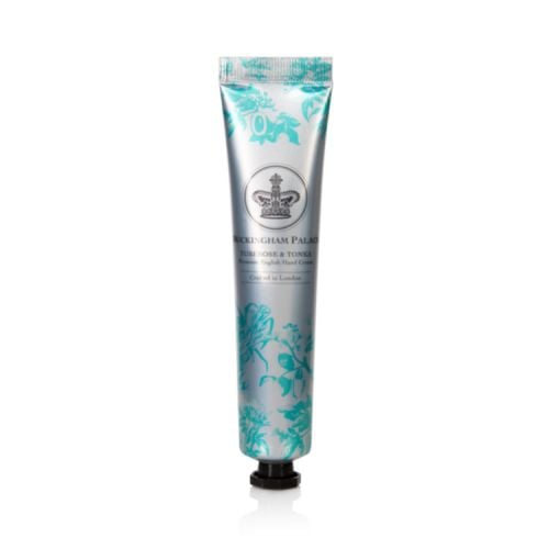 Silver tube of hand cream with a turquoise design of the ingredients. A silver crown is in the middle of the design
