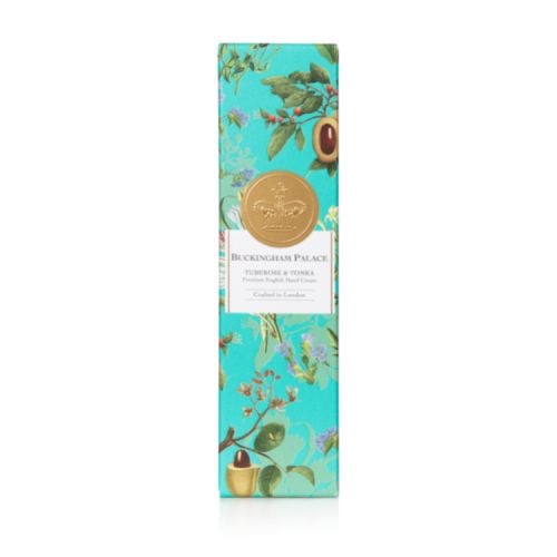 Silver tube of hand cream with a turquoise design of the ingredients. A silver crown is in the middle of the design