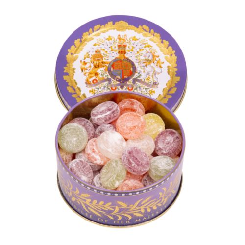 Open tin of sweets. The lid of the tin features a coat of arms and surrounded by a gold leaf design